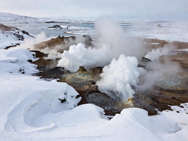 Documentary photograph of steaming geothermal vents surrounded by snow drifts near Lake Mývatn in North Iceland